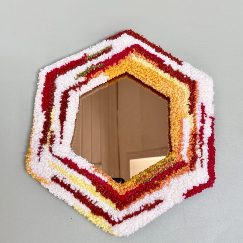 Håndlavet tuftet spejl med ramme i garnrester i røde, orange, gule og hvide nuancer, ca. 24 x 27 cm, klar til ophæng
